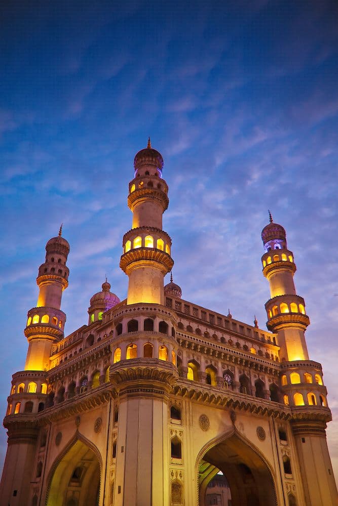 Charminar illuminated at dusk with Laad Bazaar in the foreground